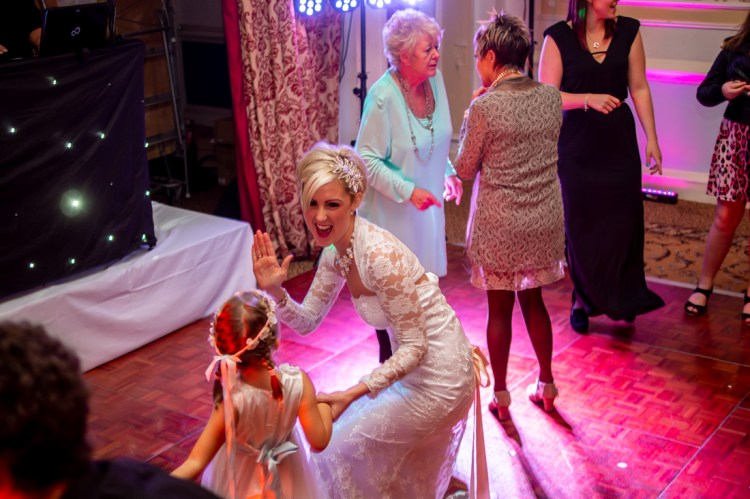 The bride having fun with young guests on the dancefloor, during the evening wedding reception at the Old Ship Hotel in Brighton, East Sussex.