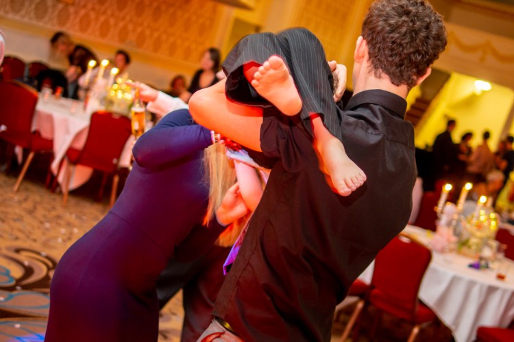 Guests pick up a young boy on the dancefloor during the evening wedding reception at the Old Ship Hotel in Brighton, East Sussex.
