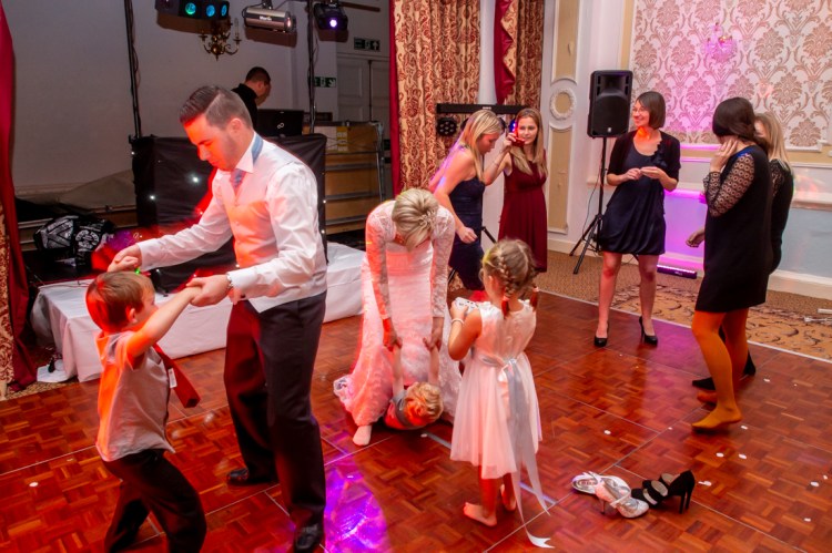 The bride and groom dance with young guests during the evening wedding reception at the Old Ship Hotel in Brighton, East Sussex.