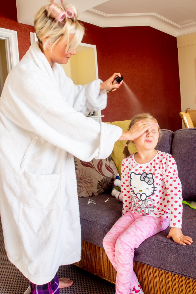 The bride sprays her daughter's hair, ahead of a wedding at the Old Ship Hotel in Brighton, East Sussex.