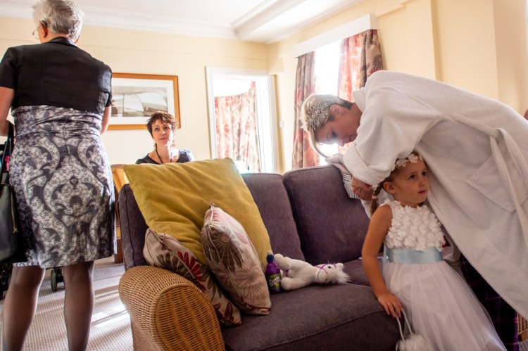 The bride attends to her daughter's hair, ahead of a wedding at the Old Ship Hotel in Brighton, East Sussex.