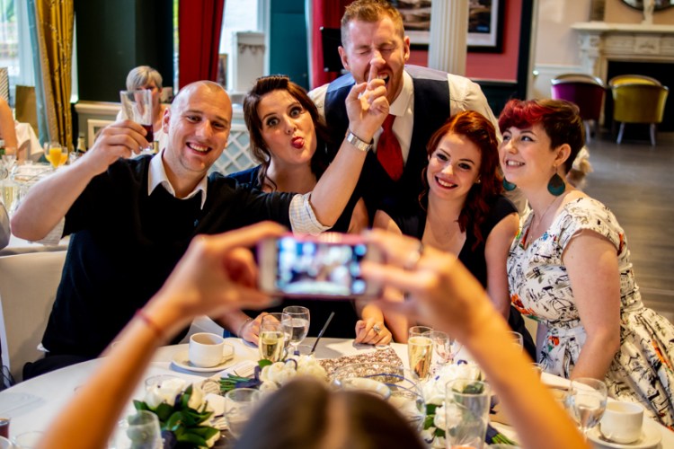 Wedding photojournalism of a gust sticking a finger up the groom's nose during a wedding at Bromley Court Hotel in Kent. Taken by Bristol wedding photographer, Darren Lehane.