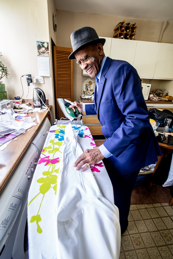 Natural wedding photography of a guest ironing the groom's shirt before a wedding in Lambeth, London. Taken by Bristol wedding photographer, Darren Lehane.