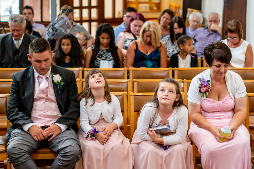 Candid wedding photography of bored guests at a wedding in Lindfield, West Sussex. Taken by Bristol wedding photographer, Darren Lehane.