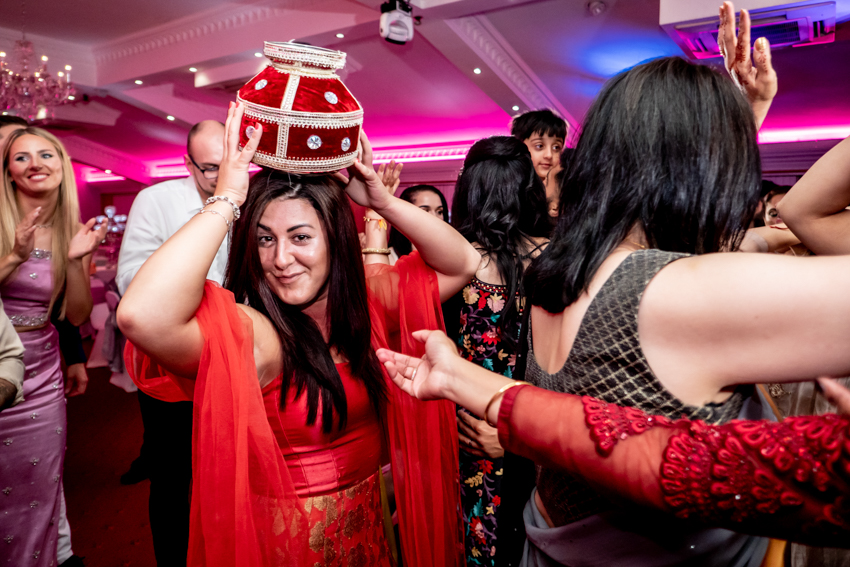 Wedding photojournalism of guests celebrating during a Sikh wedding in Mitcham, London. Taken by Bristol wedding photographer, Darren Lehane.