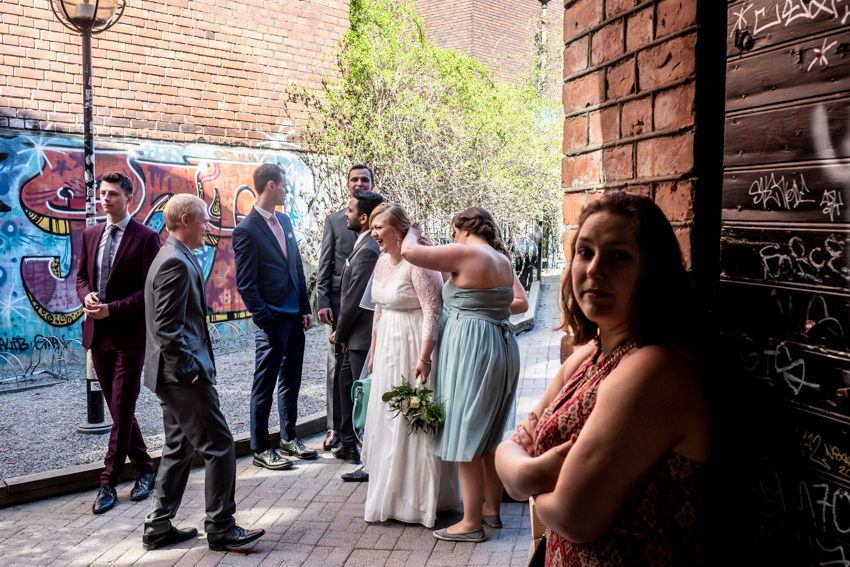 Natural wedding photography of the bride having her veil adjusted, during a wedding in Tampere, Finland.