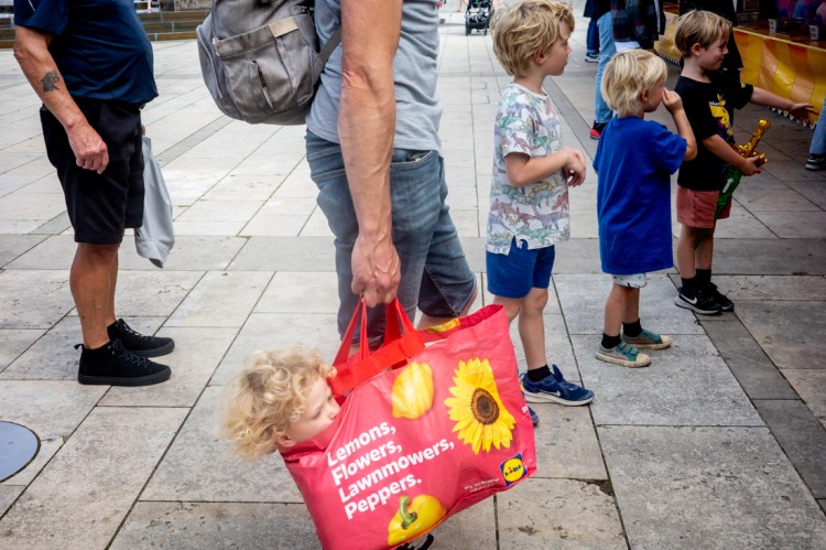 A child's head emerges from a carrier bag in Bristol.