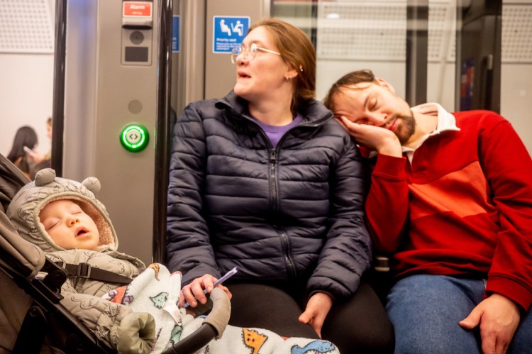 An exhausted family asleep on the London Underground,