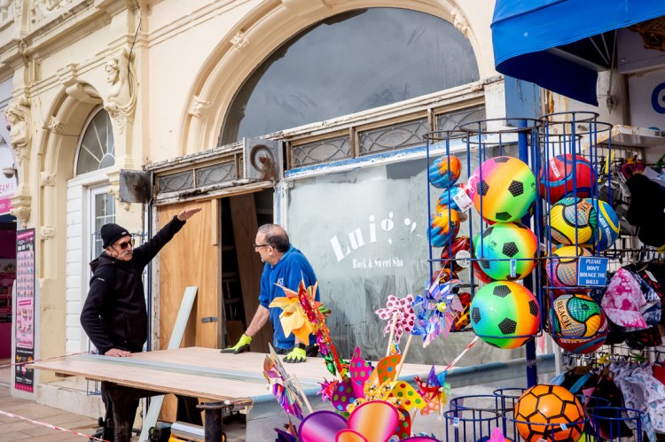 A man raises his arm near colourful beach balls in Weston-super-Mare.