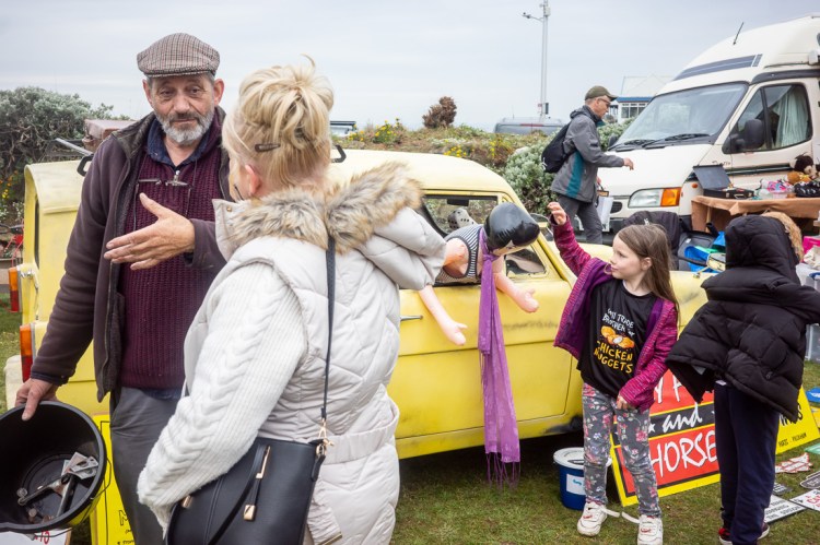Candid street photography of a young girl touching a plastic sex doll in Weston-super-Mare.