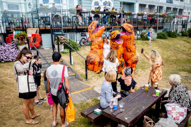 Candid street photography of inflatable dinosaurs in a pub garden in Weston-super-Mare