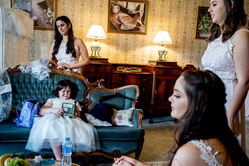The flower girl reads during the bridal preparations at Grittleton House in Wiltshire.