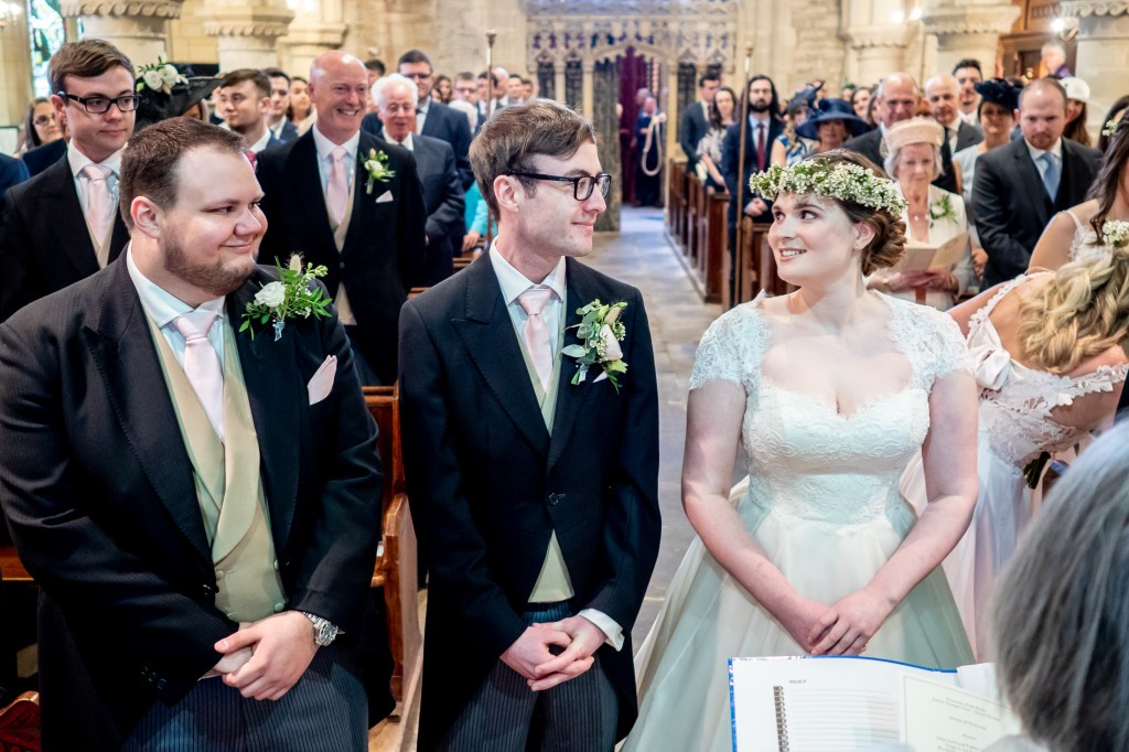 The bride and groom look at one another during the wedding ceremony at Grittleton House in Wiltshire.