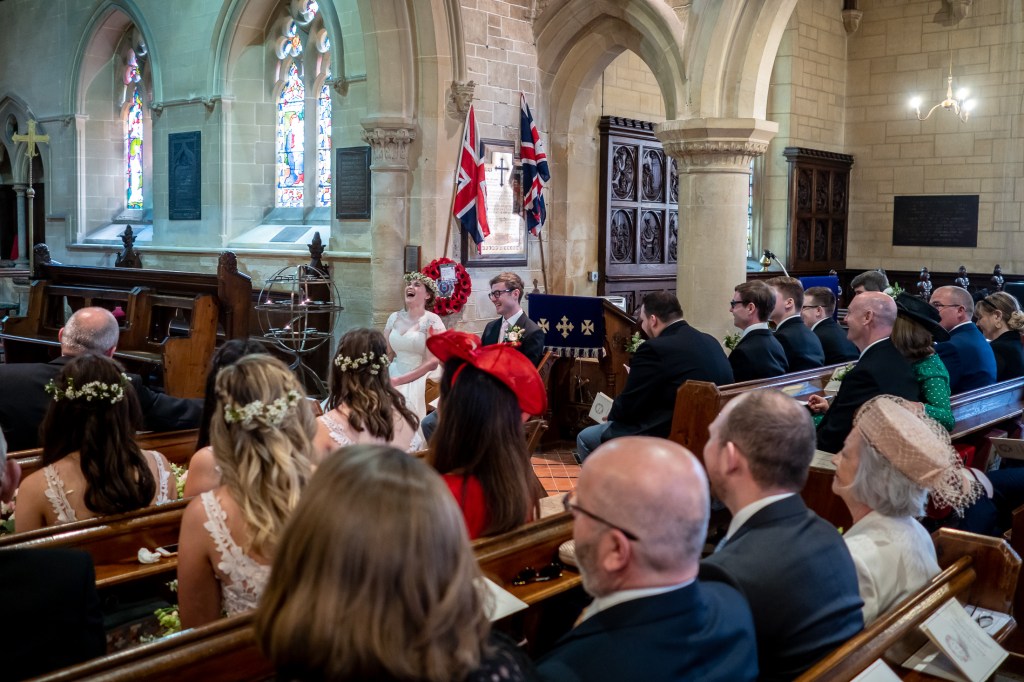 The bride laughs loudly during the wedding ceremony at Grittleton House in Wiltshire.