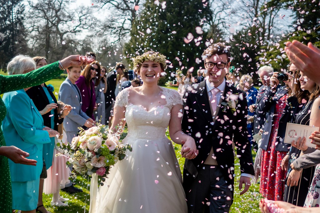 The couple are showered with confetti during a wedding at Grittleton House in Wiltshire.