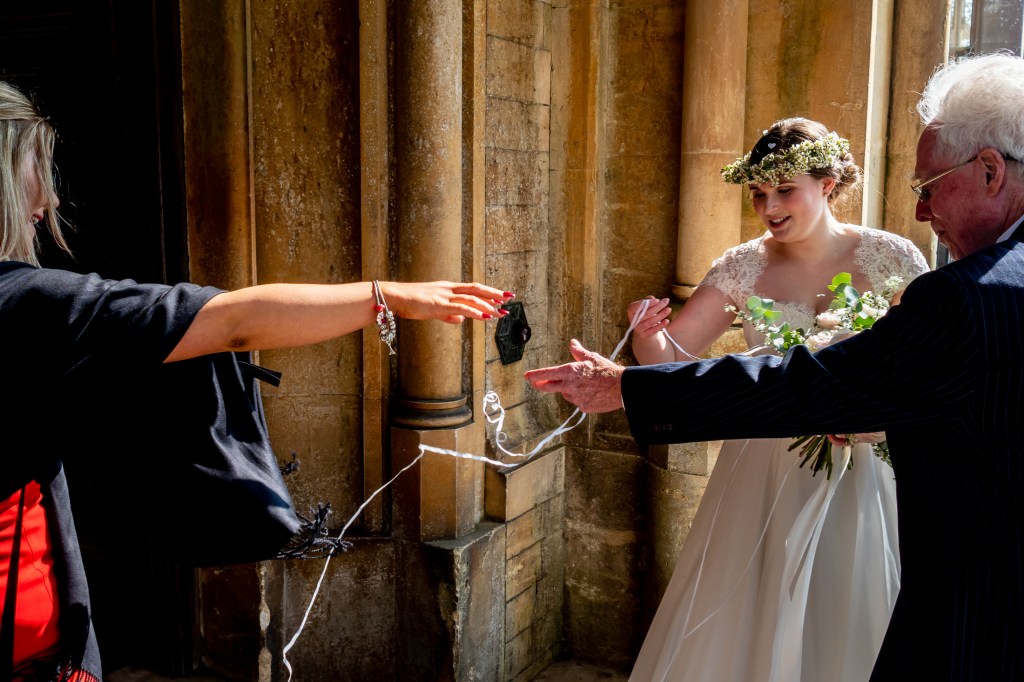 Wedding guests help the bride untangle from confetti at Grittleton House in Wiltshire.