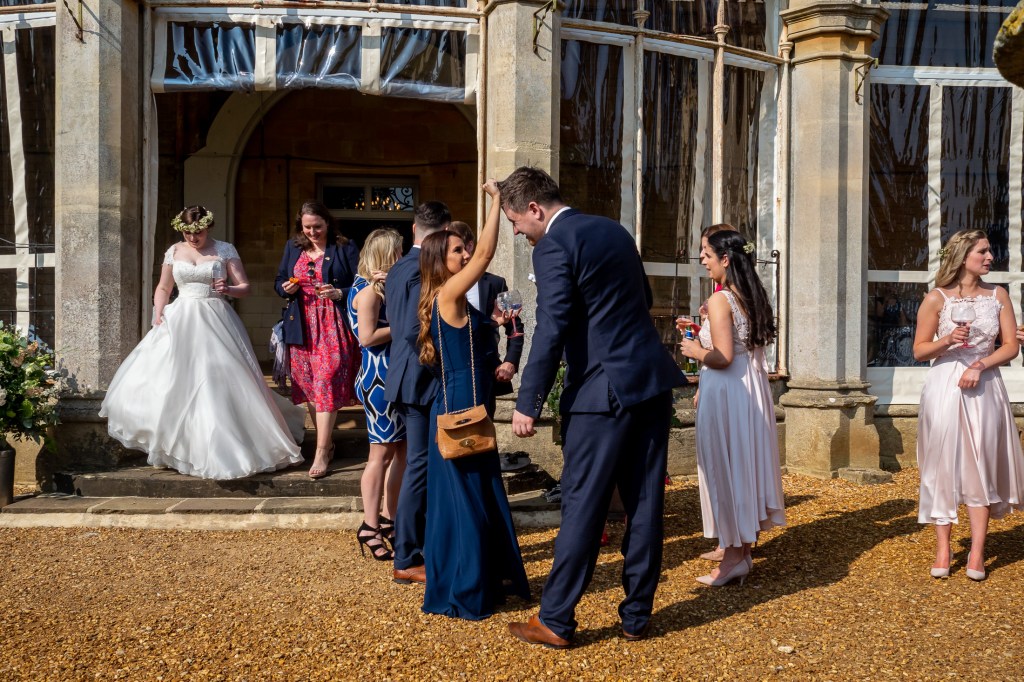 A wedding guest sorts out the hair of her partner at Grittleton House in Wiltshire.