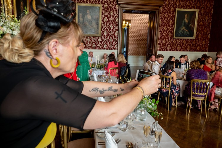 The a guesy takes a photo during wedding breakfast at Grittleton House in Wiltshire.