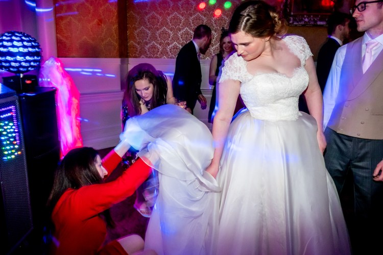 Guests sorting out the bride's wedding dress at Grittleton House in Wiltshire.