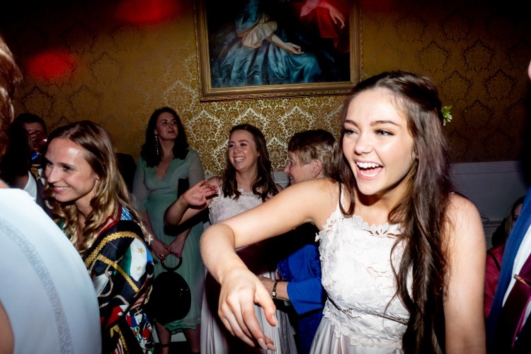 A bridesmaid laughs during the evening wedding reception at Grittleton House in Wiltshire.