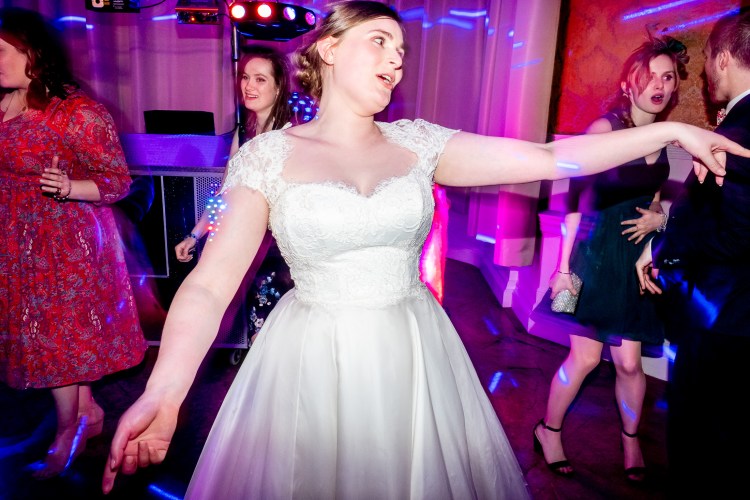 The bride reaches out on the dancefloor at Grittleton House in Wiltshire.