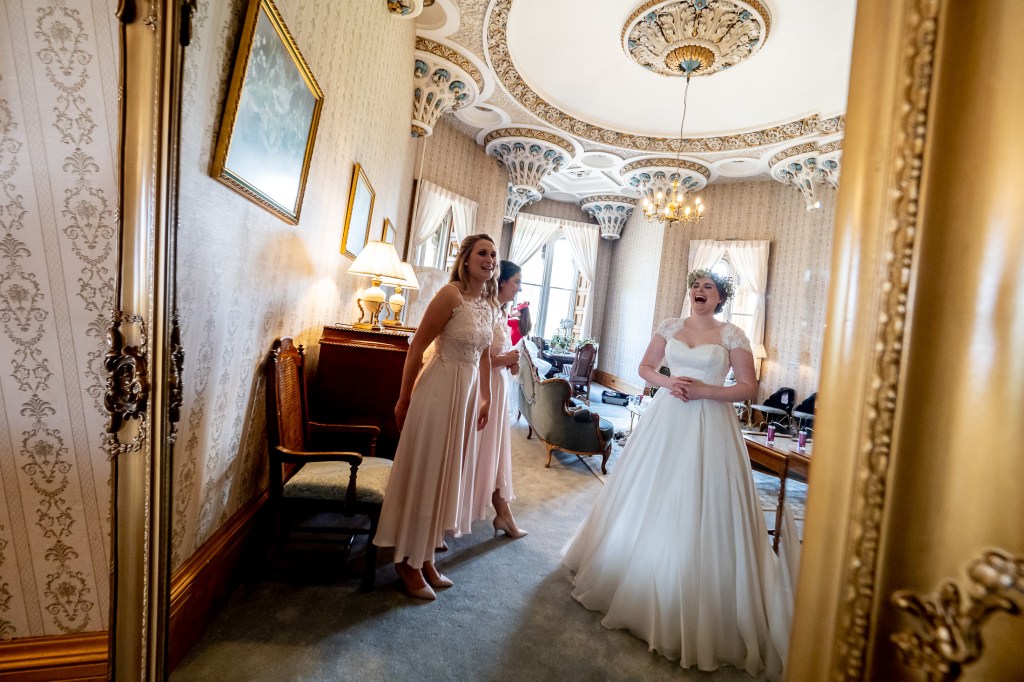 The bride laughs during the morning preparations at Grittleton House in Wiltshire.