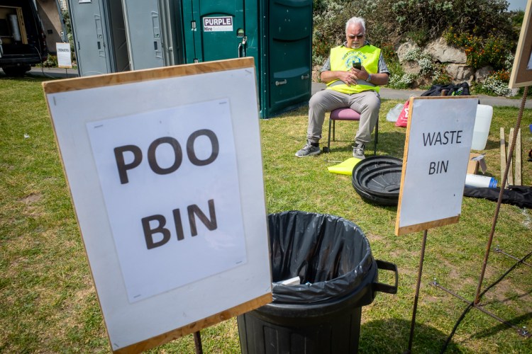 Candid street photography of a man sitting by a poo tin in Weston-super-Mare