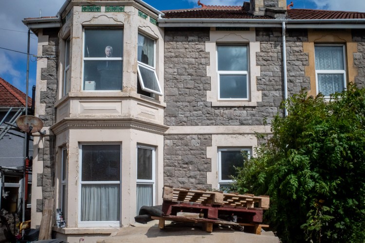 Candid street photography of Andrew Mountbatten-Windoe looking out a window in Weston-super-Mare.