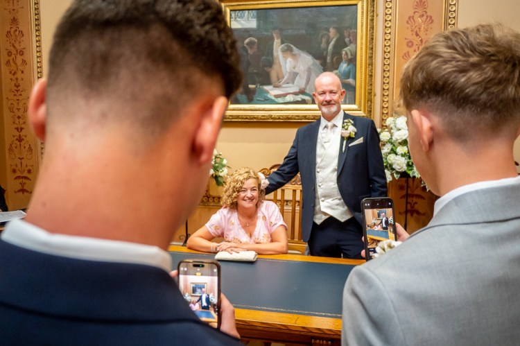 Guests take photos of he bride and groom during a wedding at Bristol Register Office in Bristol.