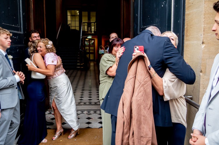 Guests hug the bride and groom after a wedding at Bristol Register Office in Bristol.