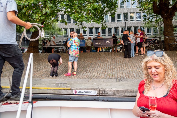 Passers-by at the riverbank, during a Bristol wedding on the Flower of Bristol boat, run by Bristol Packet tour company.
