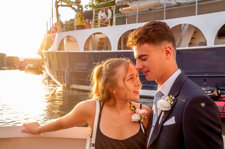 A young couple embrace during a Bristol wedding on the Flower of Bristol boat, run by Bristol Packet tour company.