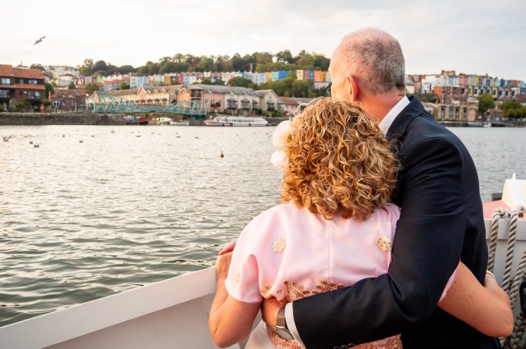 The bride and groom look out across the River Avon, during a Bristol wedding on the Flower of Bristol boat, run by Bristol Packet tour company.