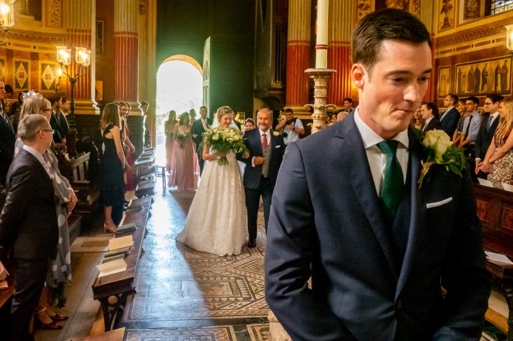 A nervous groom waits as the bride comes up the aisle at a wedding at Worcester College in Oxford.