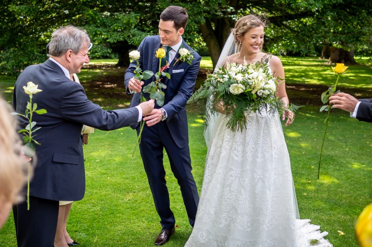 The bride and groom accept flowers from guests, during a wedding at Worcester College in Oxford.