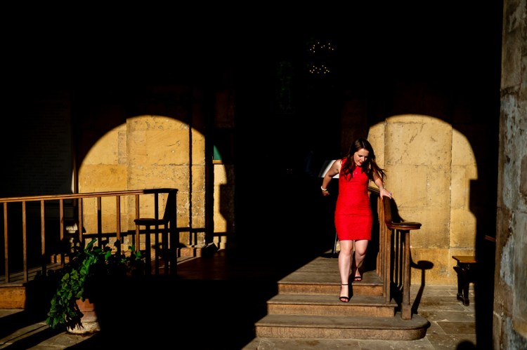 A female guest in red dress at a wedding at Worcester College in Oxford.
