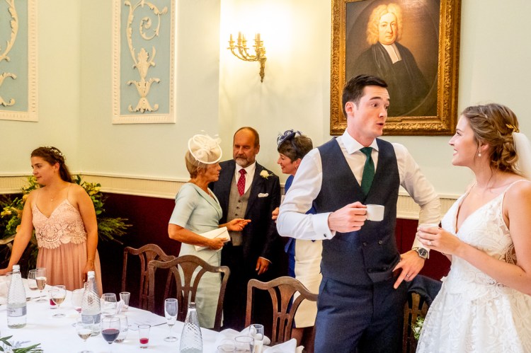 The groom, with a cup of tea, chats to the bride during a wedding at Worcester College in Oxford.