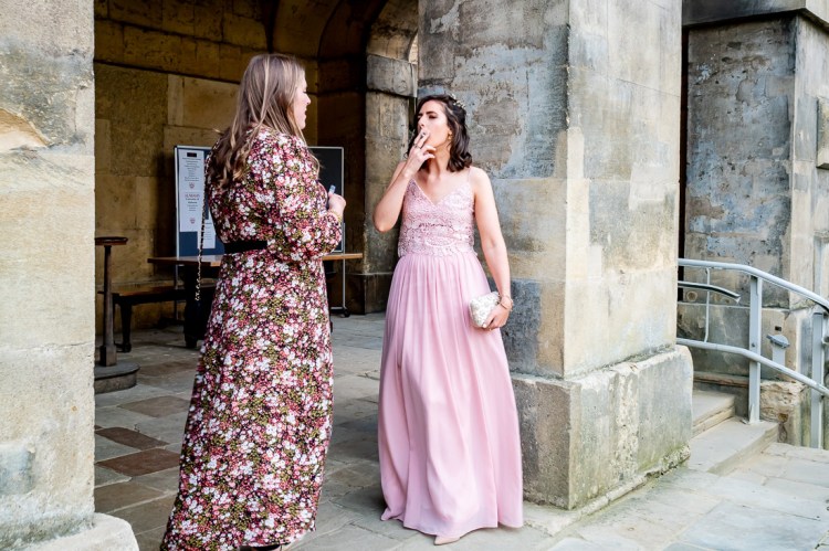 A bridesmaid enjoys a cigarette during a wedding at Worcester College in Oxford.