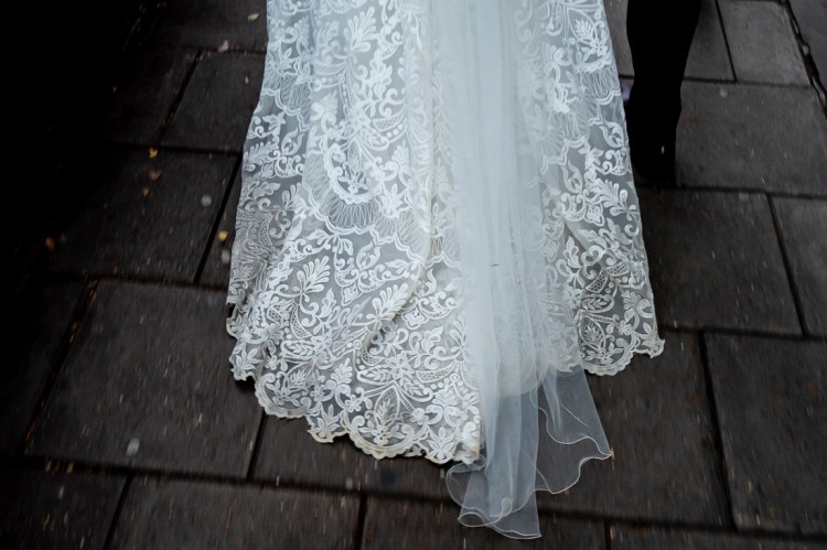 A detail of the bride's dress on the pavement during a wedding day in Oxford.