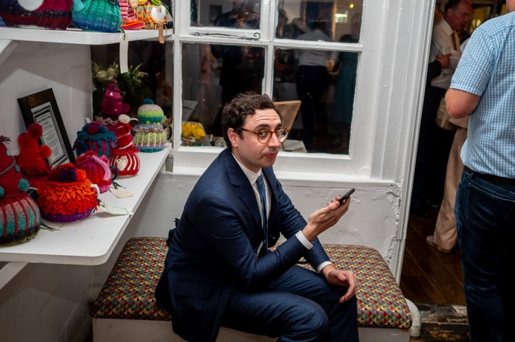 A male guest om his mobile phone, during the evening wedding reception at the Jam Factory in Oxford.