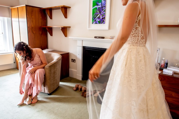 A bridesmaid puts on her shoes, during the bridal preps, ahead of a wedding at Worcester College in Oxford.