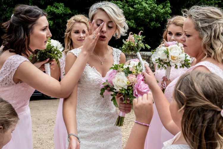 A bridesmaid wipes makeup away from the brides face, before a wedding near Bournemouth in Dorset.