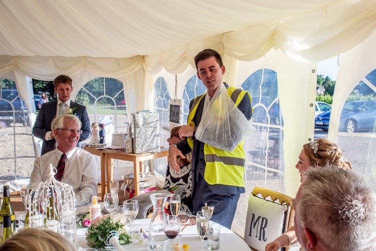 THe groom with his arm in a sling, during the speeches at a wedding at Highdown Vineyard in West Sussex.