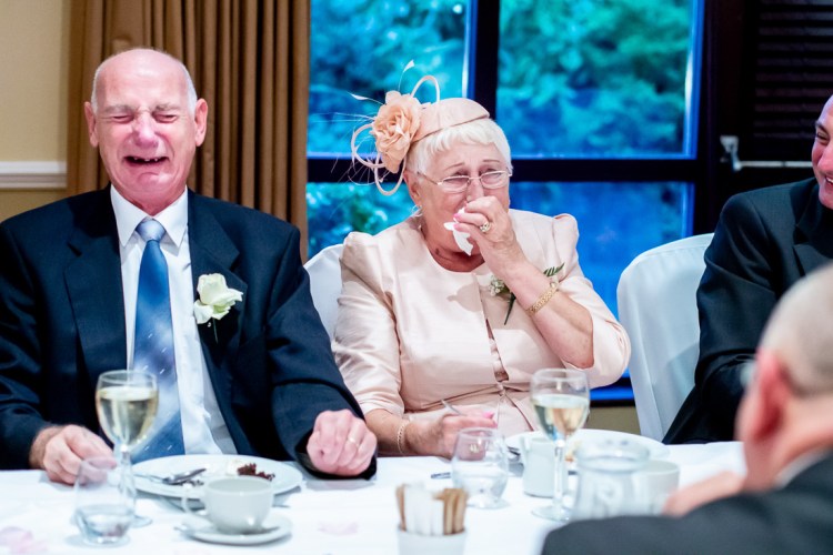 Parents of the groom laugh during the wedding speeches at Meon Valley Hotel near Southampton in Hampshire.