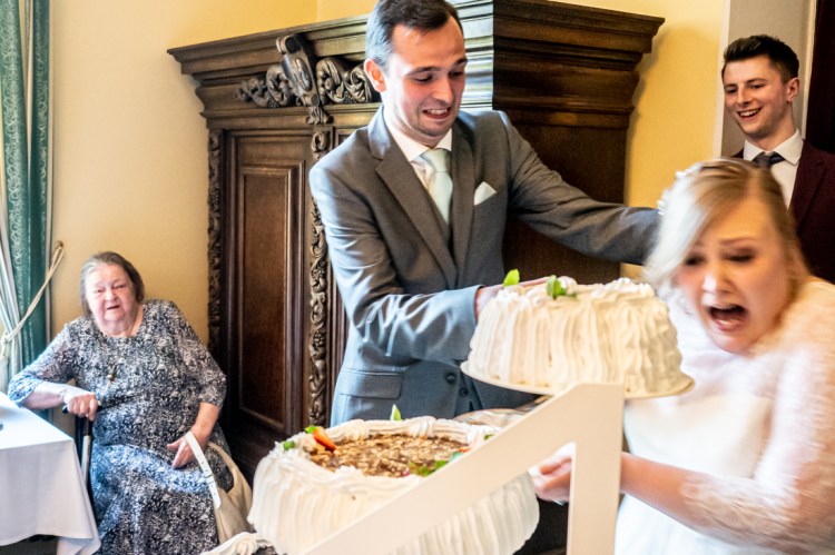 THe groom chases the bride with wedding cake, during a wedding in Tampere, Finland.