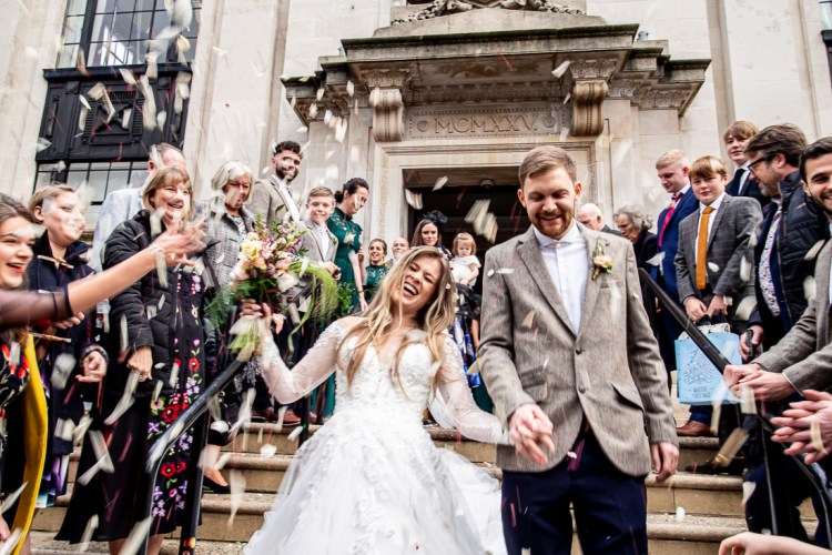 The bride and groom are showered with confetti during wedding at Islington Town Hall in London.