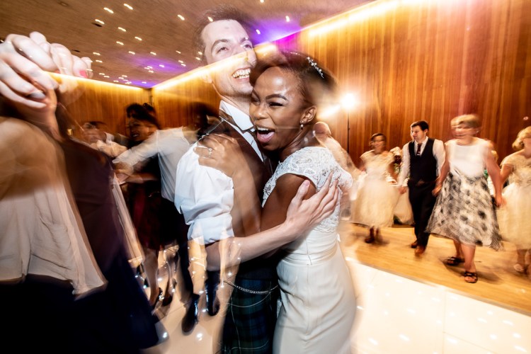 Bride and groom laughing on the dancefloor during a wedding at Wandsworth Town Hall in London.