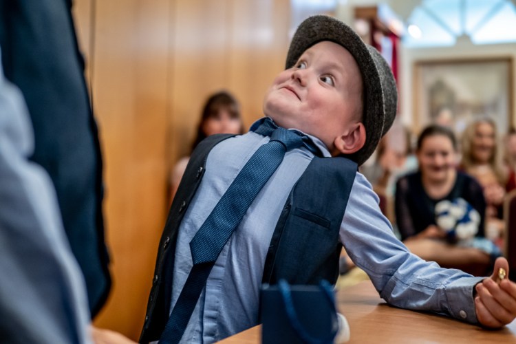 The young ringbearer pulls a funny face during a wedding at Kettering Registry Office in Northants.