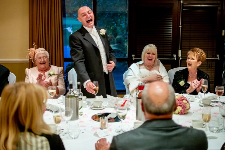 The groom laughs during his speech at a wedding at the Meon Valley Hotel in Hampshire.